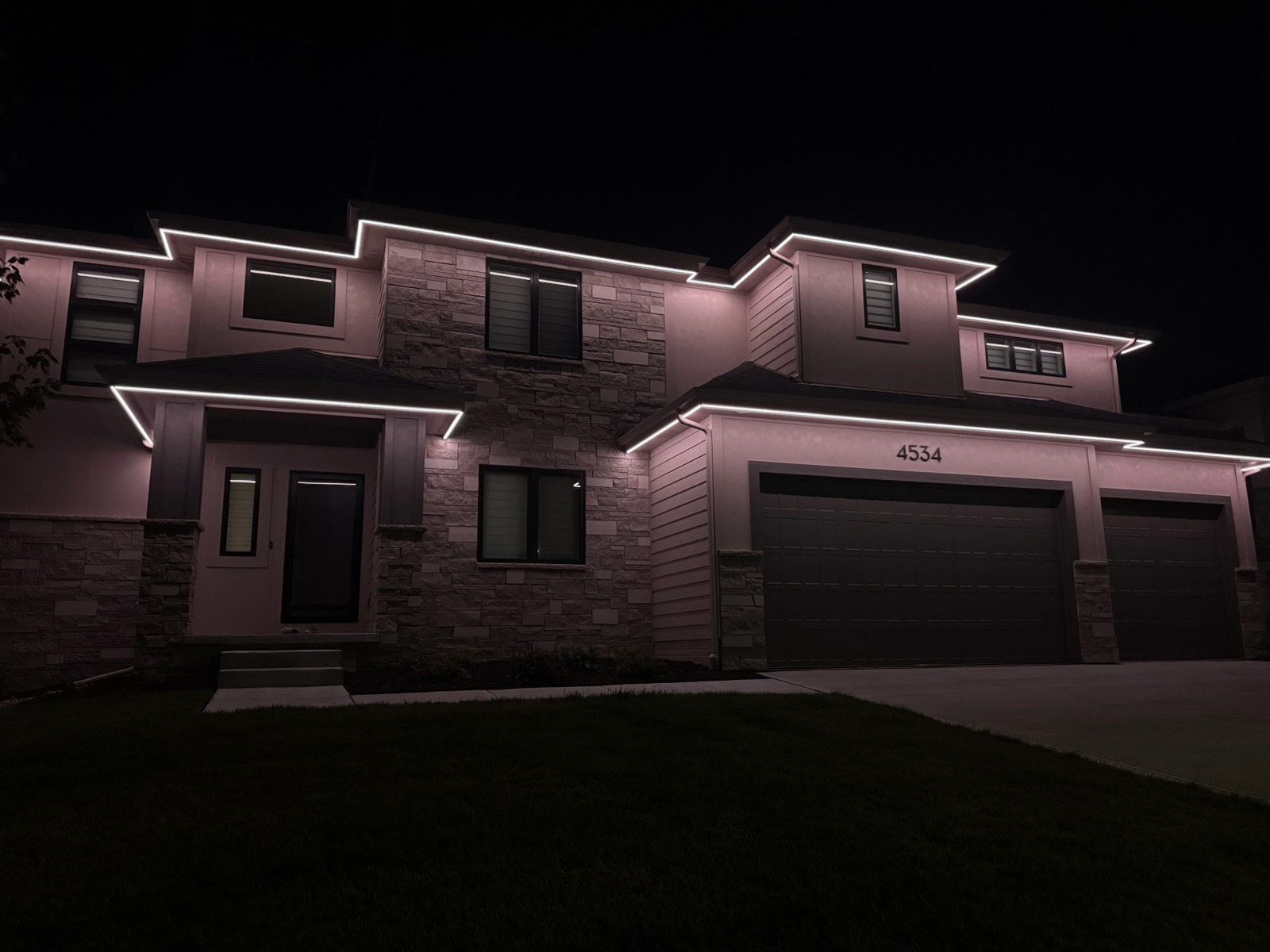 Home with Brytr permanent roofline lighting installed, lit up at night